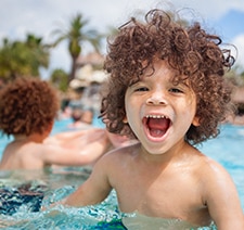 Two curly headed boys playing in a pool
